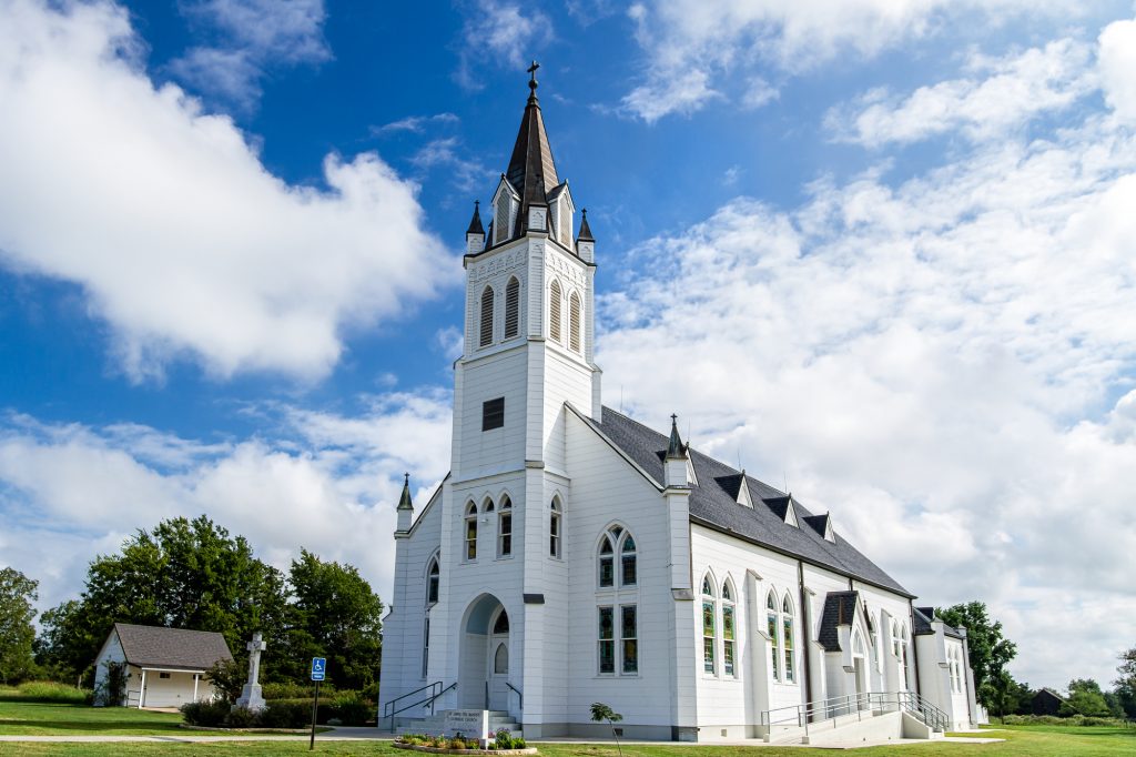 Large white church and blue sky with some clouds