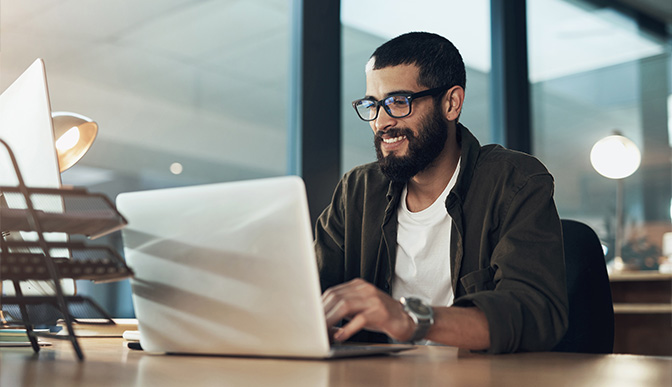 man using computer and smiling