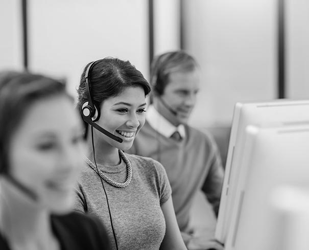 Support staff smiling on computer for technical support
