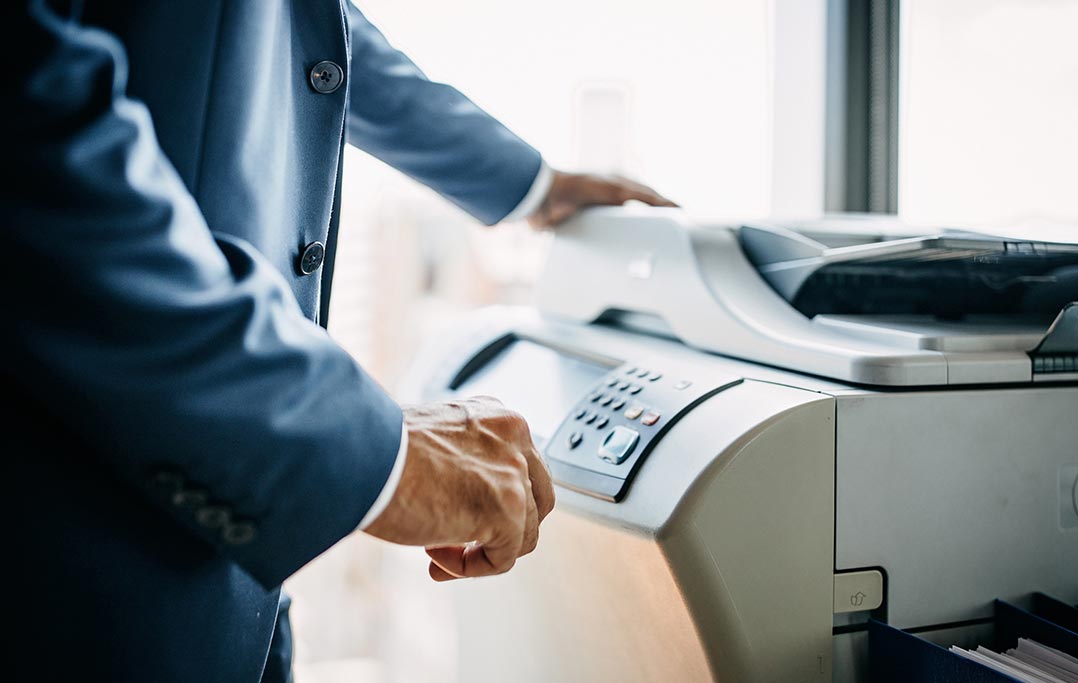 Man typing a fax number on to a fax machine